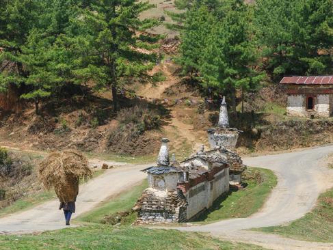 Vallée De Phobjikha - Mur De Prière Traditionnel Avec Chorten Et Homme Portant De La Paille A Découvrir au Bhoutan - La Vallée de Phobjikha