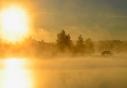 Soleil de minuit et maison dans le nord de la Finlande, Laponie Voyage en Finlande - Lumières Boréales et Aventures Arctiques